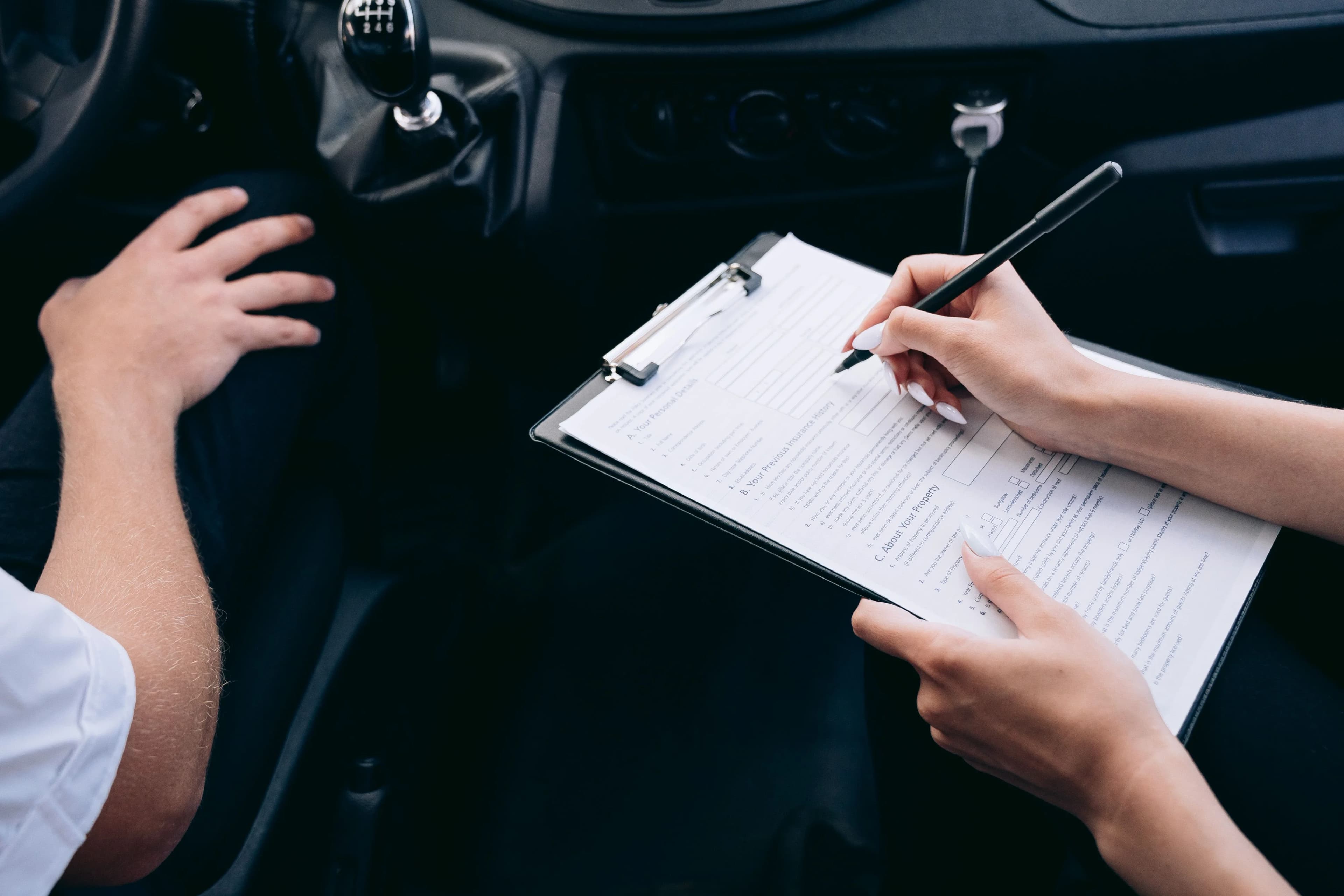 Examinator overloopt een checklist met de kandidaat tijdens het praktijkexamen