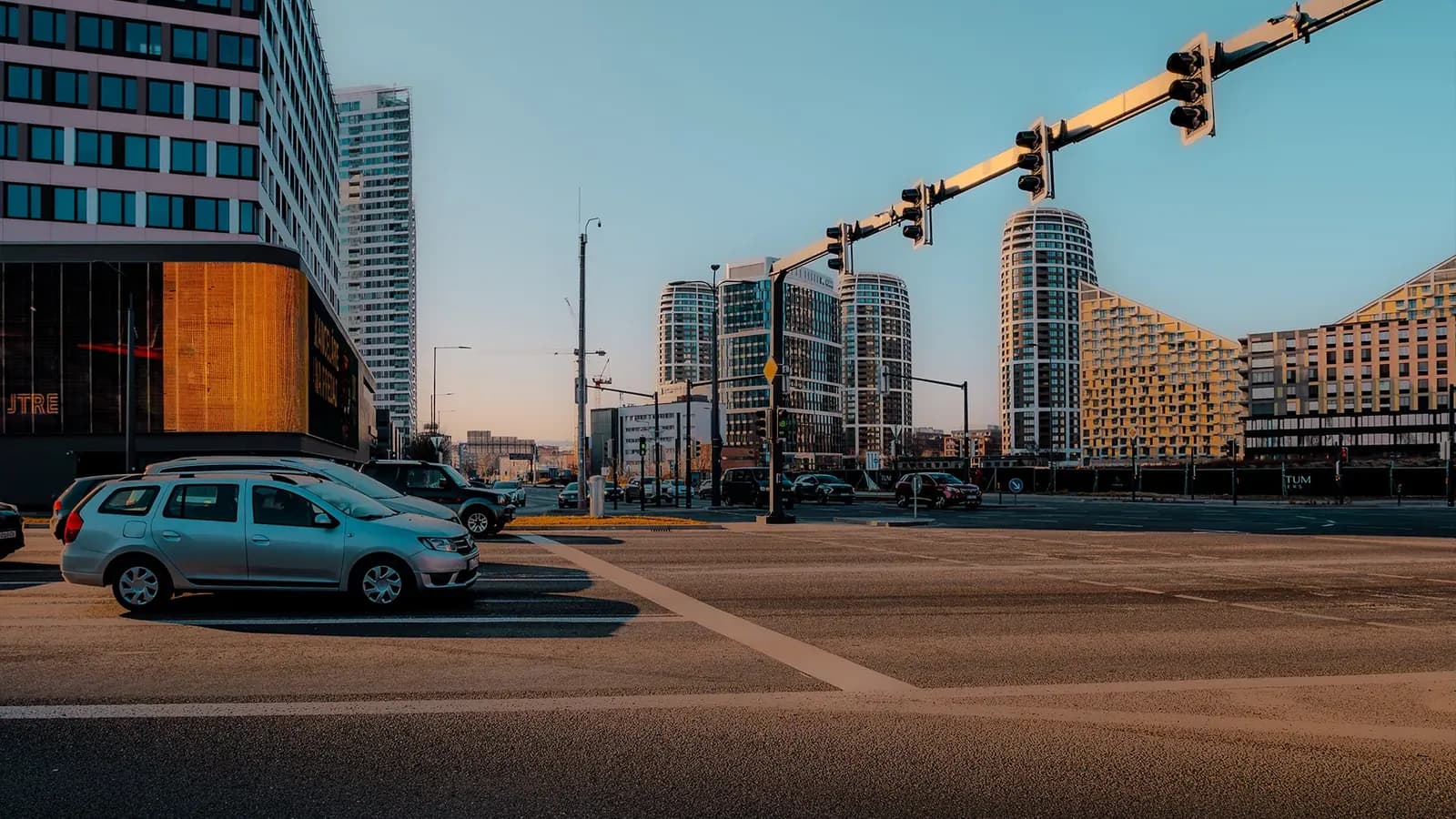 Kruispunt met verkeerslichten waar een wagen wacht om af te slaan